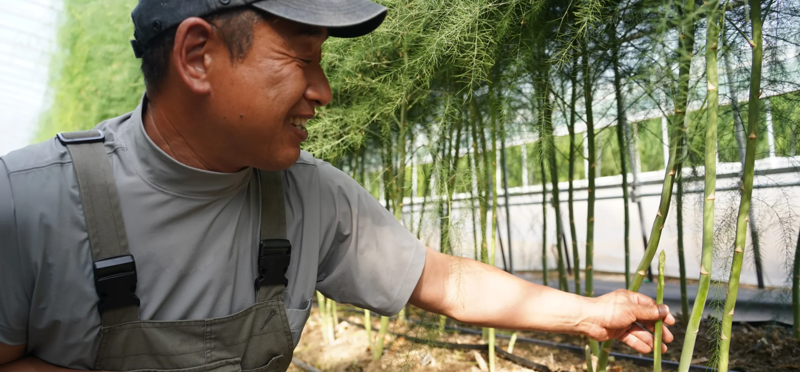 アスパラを笑顔で紹介する農家さん